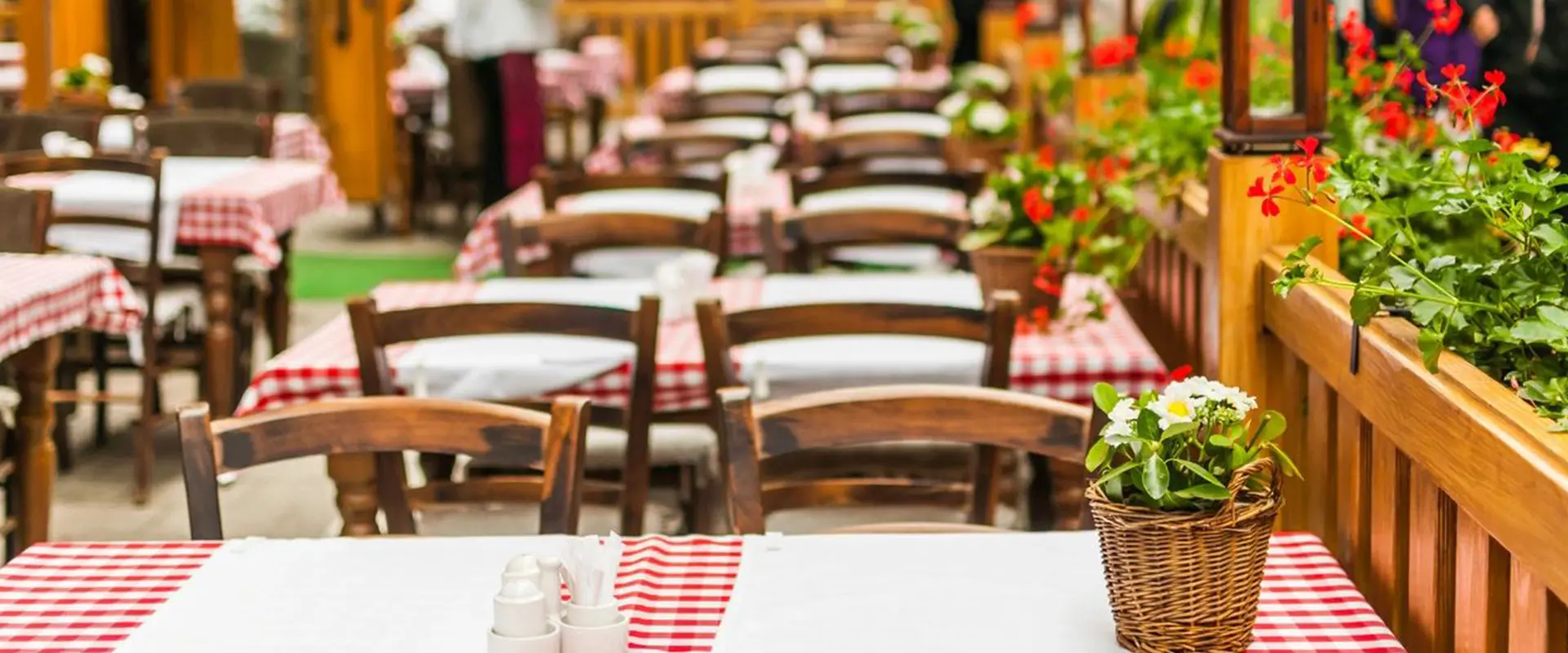 A restaurant with tables and chairs set up for dinner.